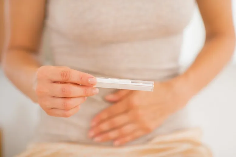 kobieta trzymająca tester ciążowy