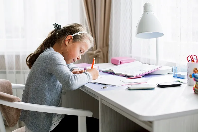 dziewczynka pilnie ucząca się przy biurku