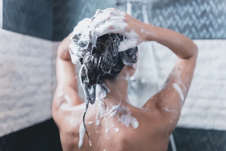 rodzaje szamponów - kobieta myjąca włosy