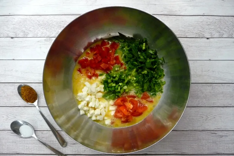 W misce roztrzep jaja i dodaj pokrojone warzywa i ser. Całość wymieszaj